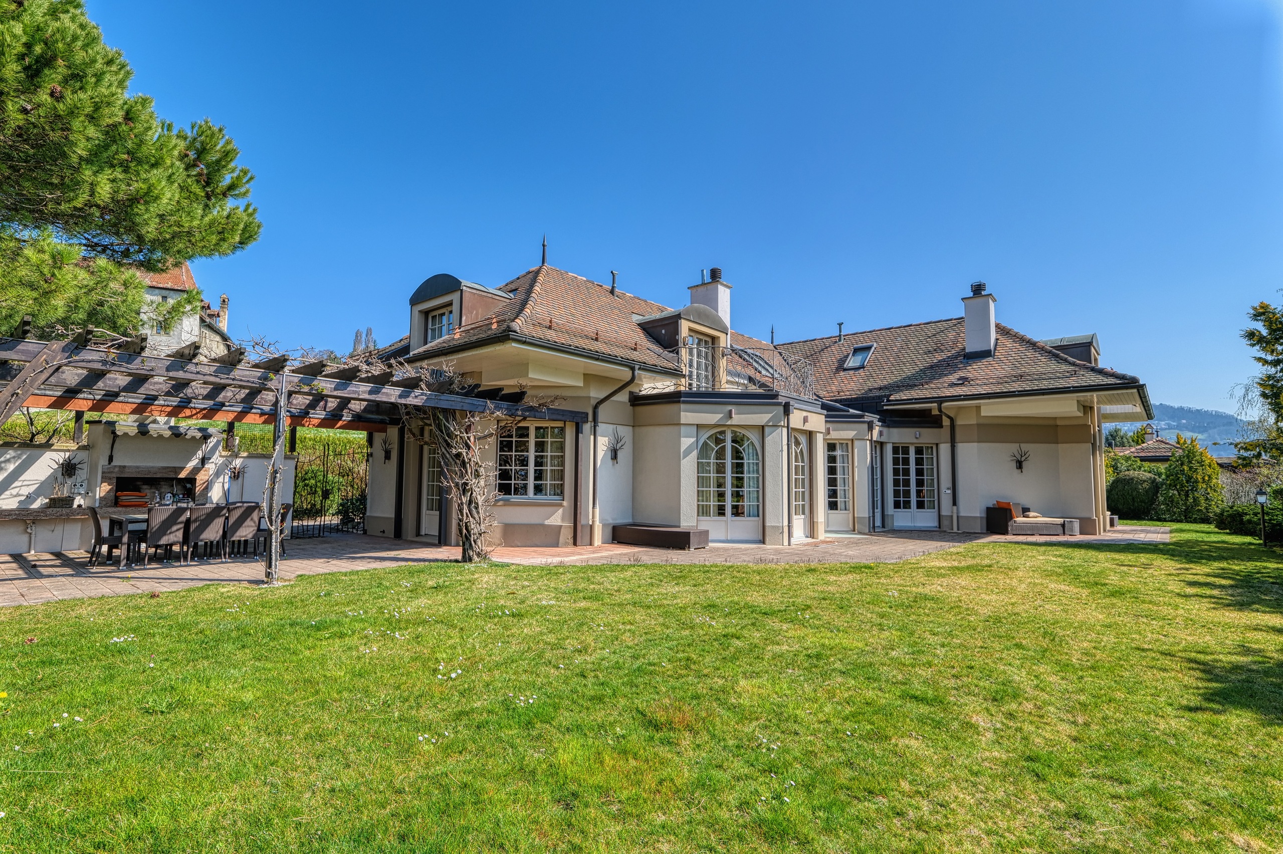 Großzügige Villenrückseite mit Garten und Pergola