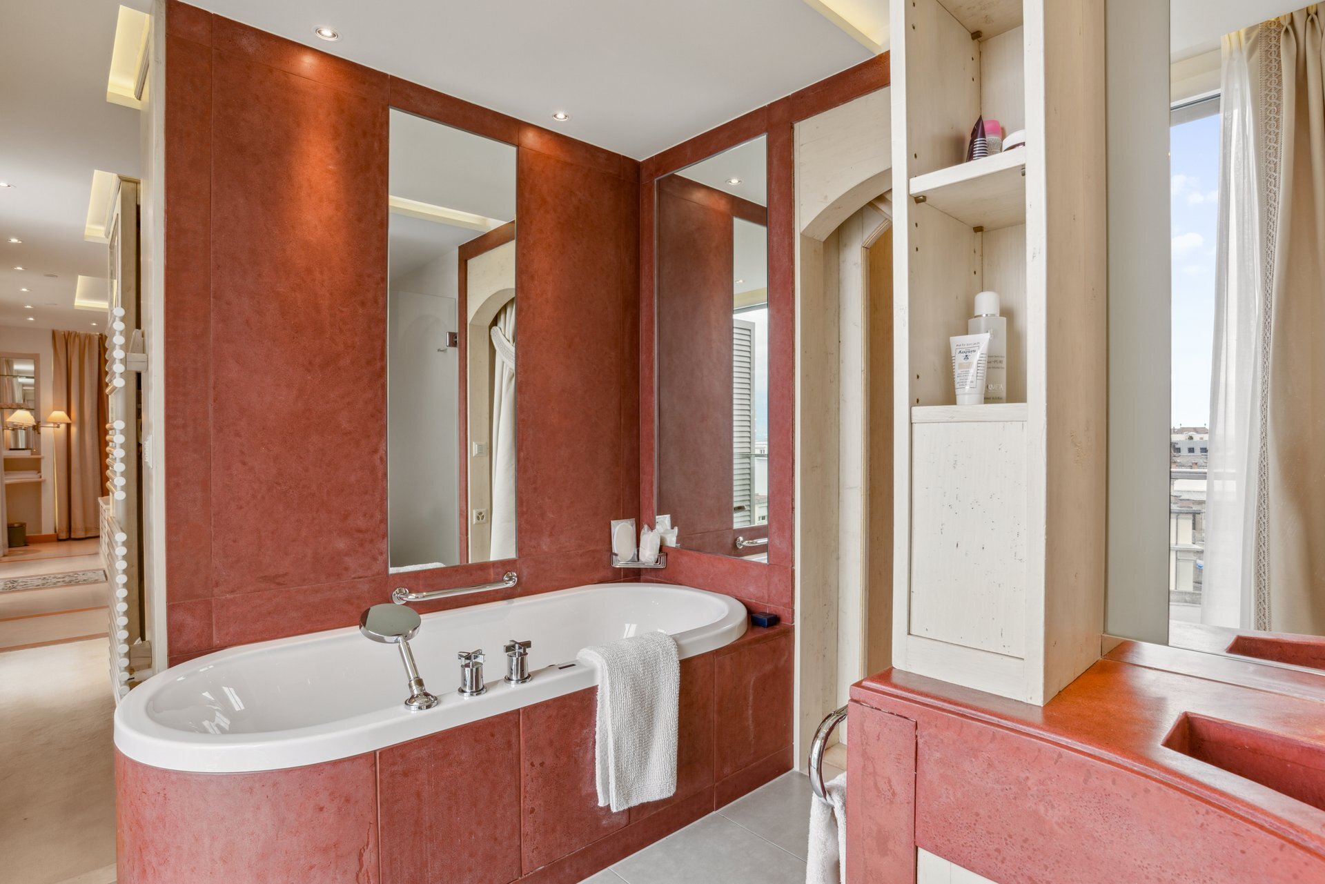 Badezimmer mit freistehender Wanne und Spiegelwand
