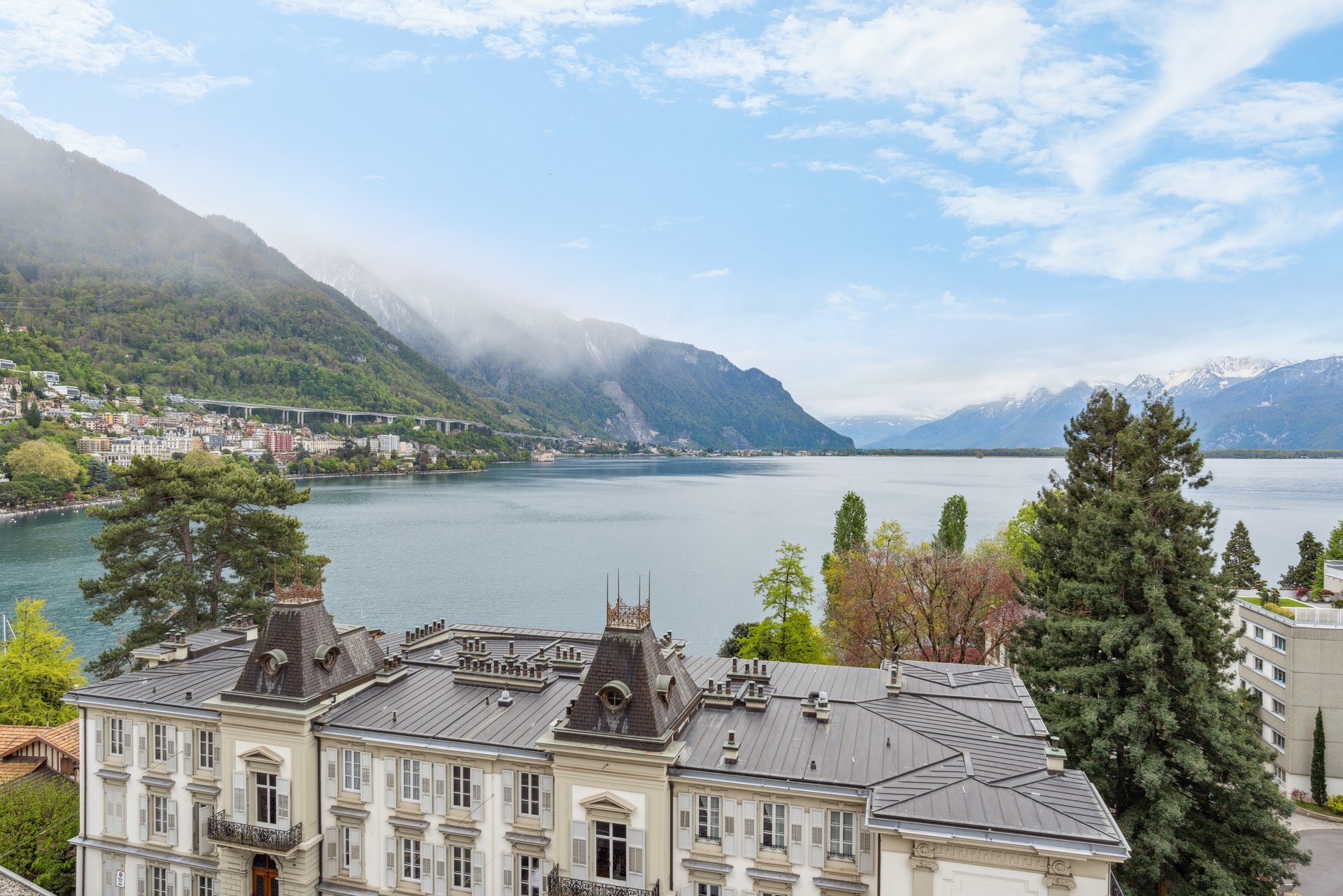 Seeblick mit Alpenpanorama und historischer Dachlandschaft