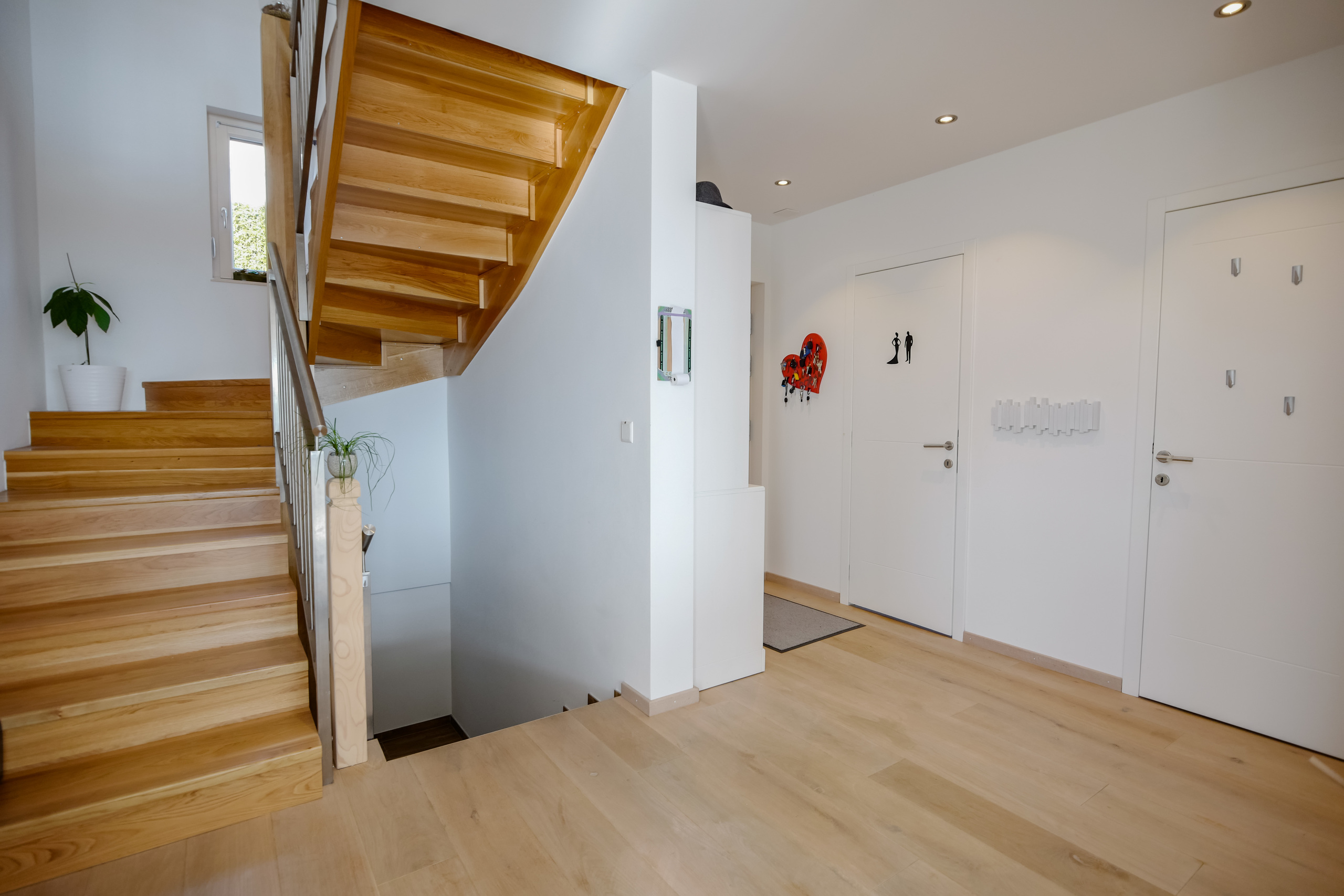 Heller Eingangsbereich mit Holztreppe