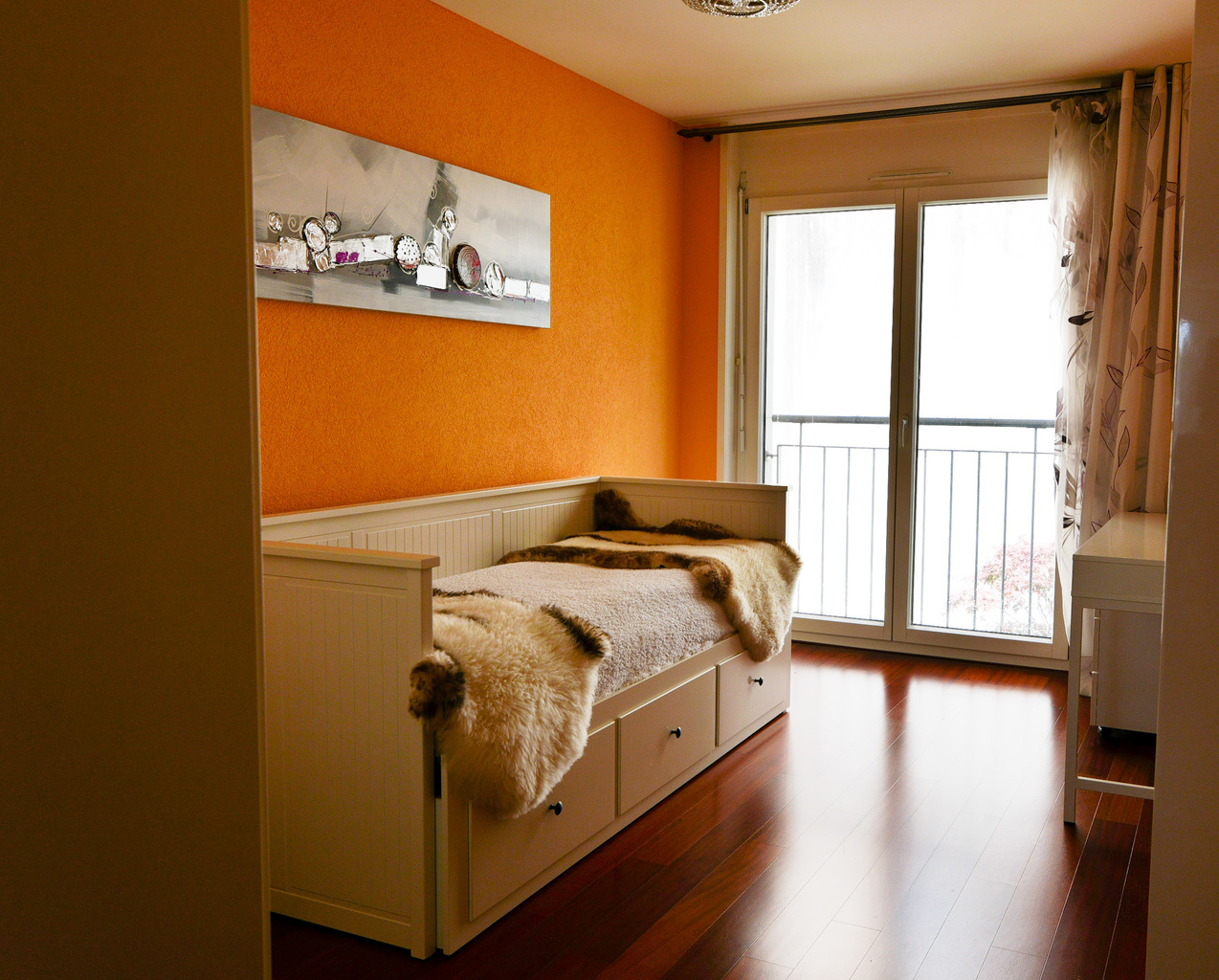 Helles Schlafzimmer mit orangefarbener Akzentwand