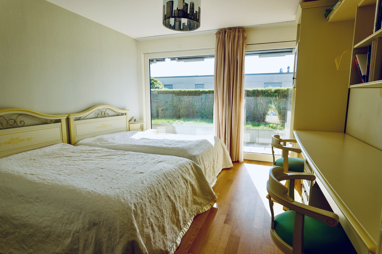 Schlafzimmer mit zwei Betten und Blick in den Garten