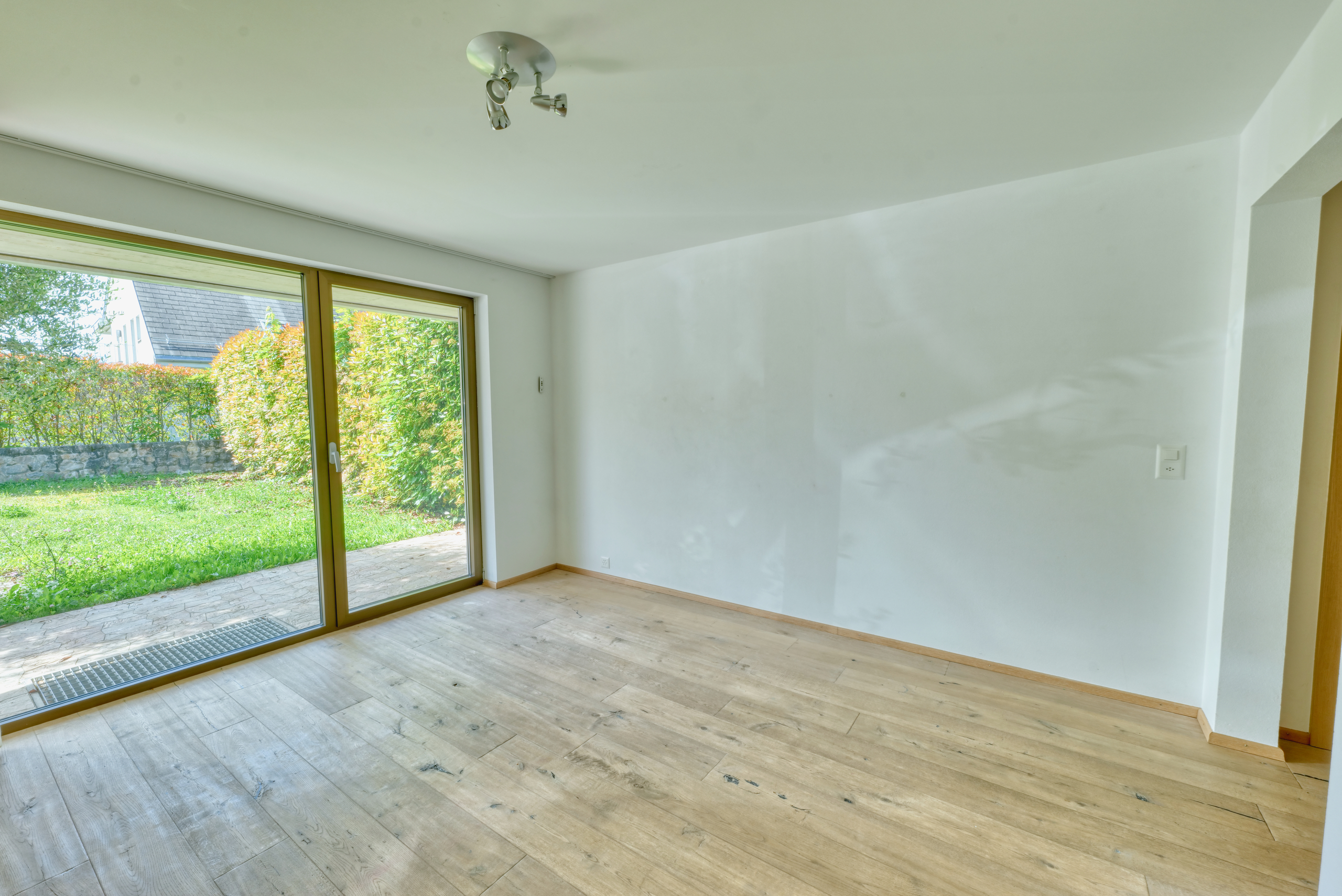 Heller leerer Wohnraum mit Gartenzugang