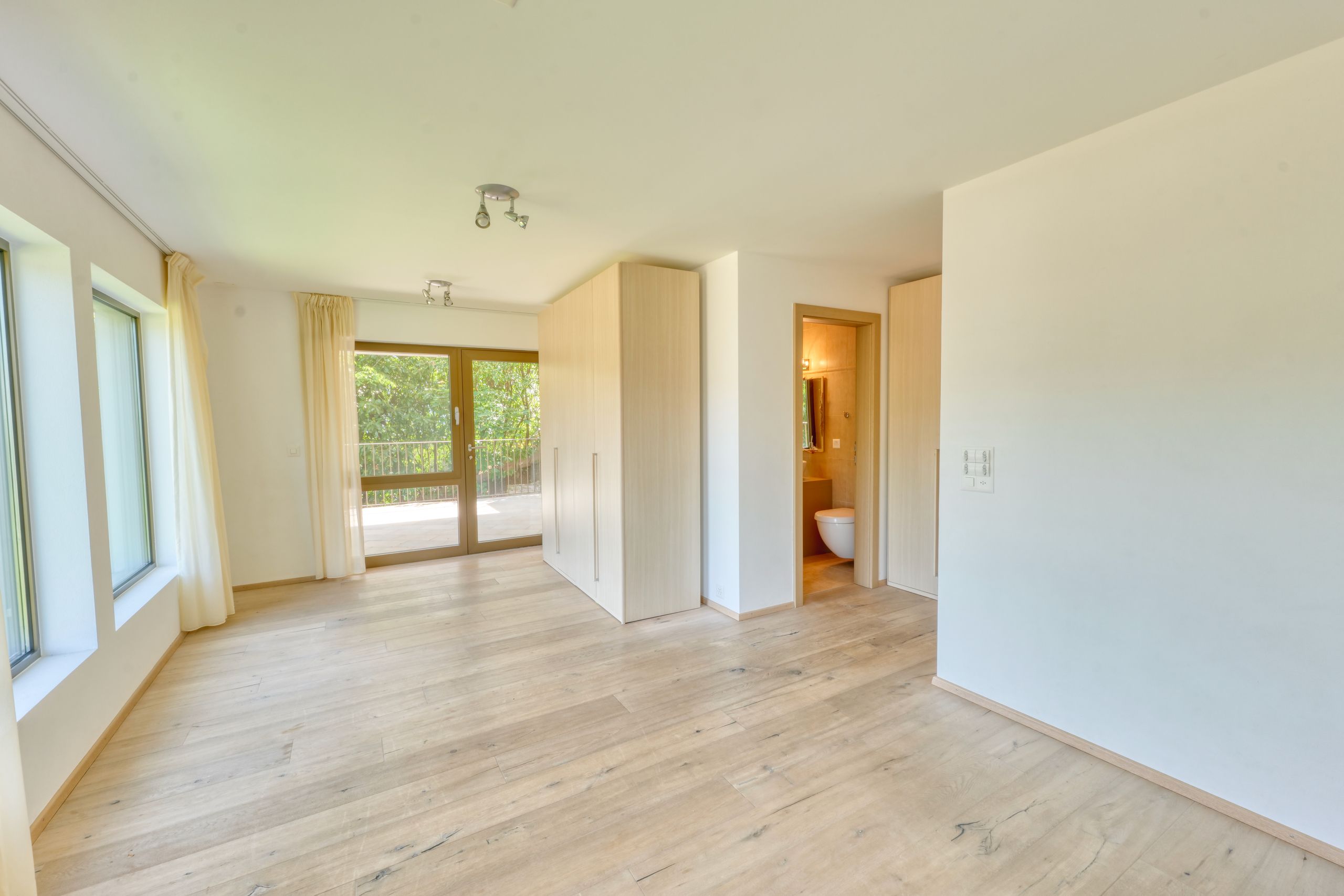 Helles Schlafzimmer mit Balkonzugang und Bad en suite