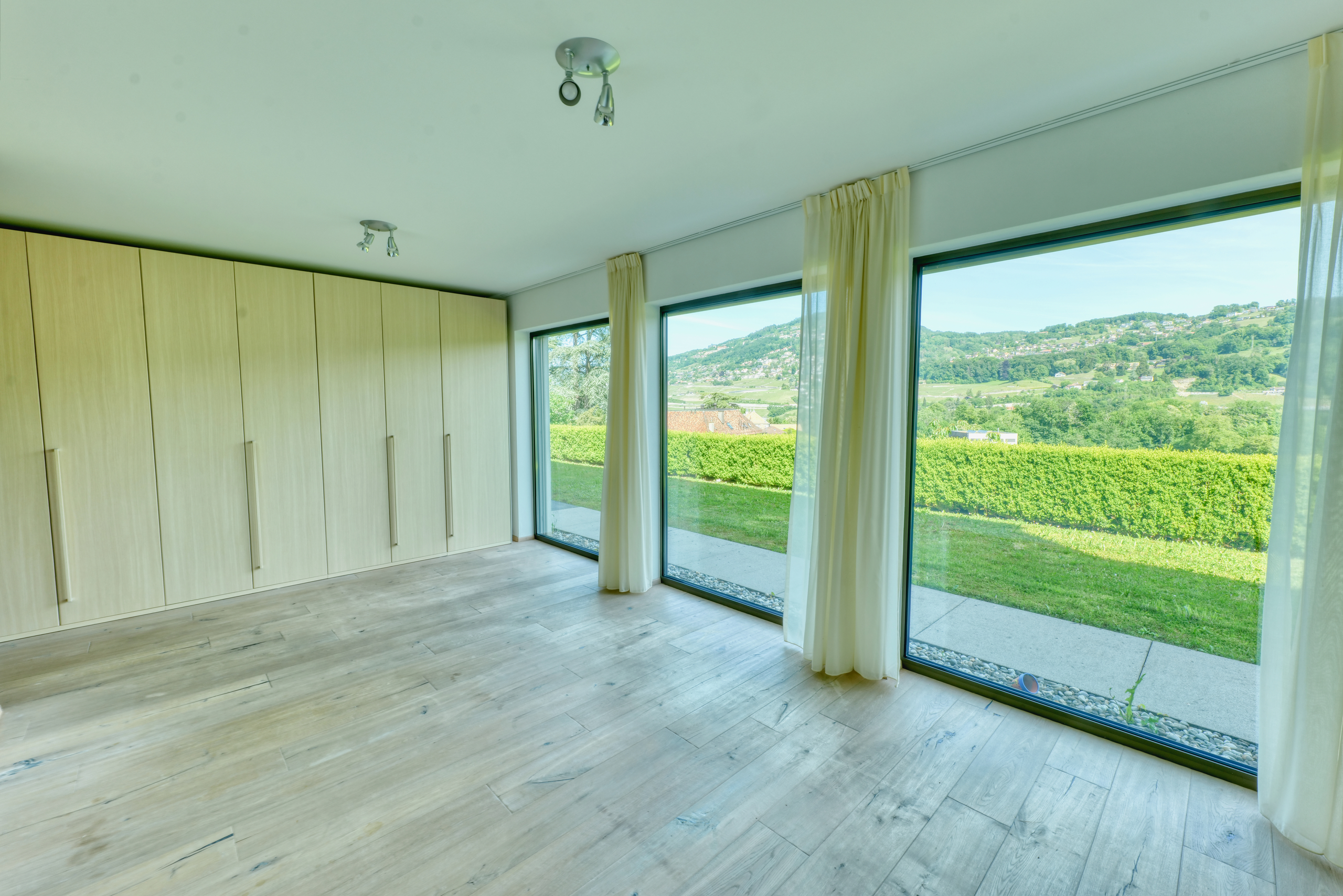 Heller leerer Raum mit Panoramafenstern und Einbauschränken