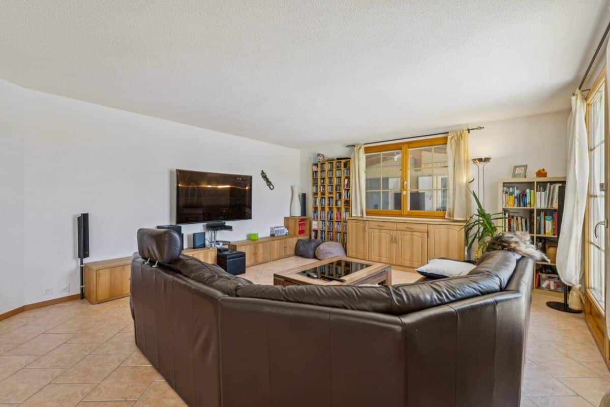 Wohnzimmer mit Ecksofa und TV-Wand
