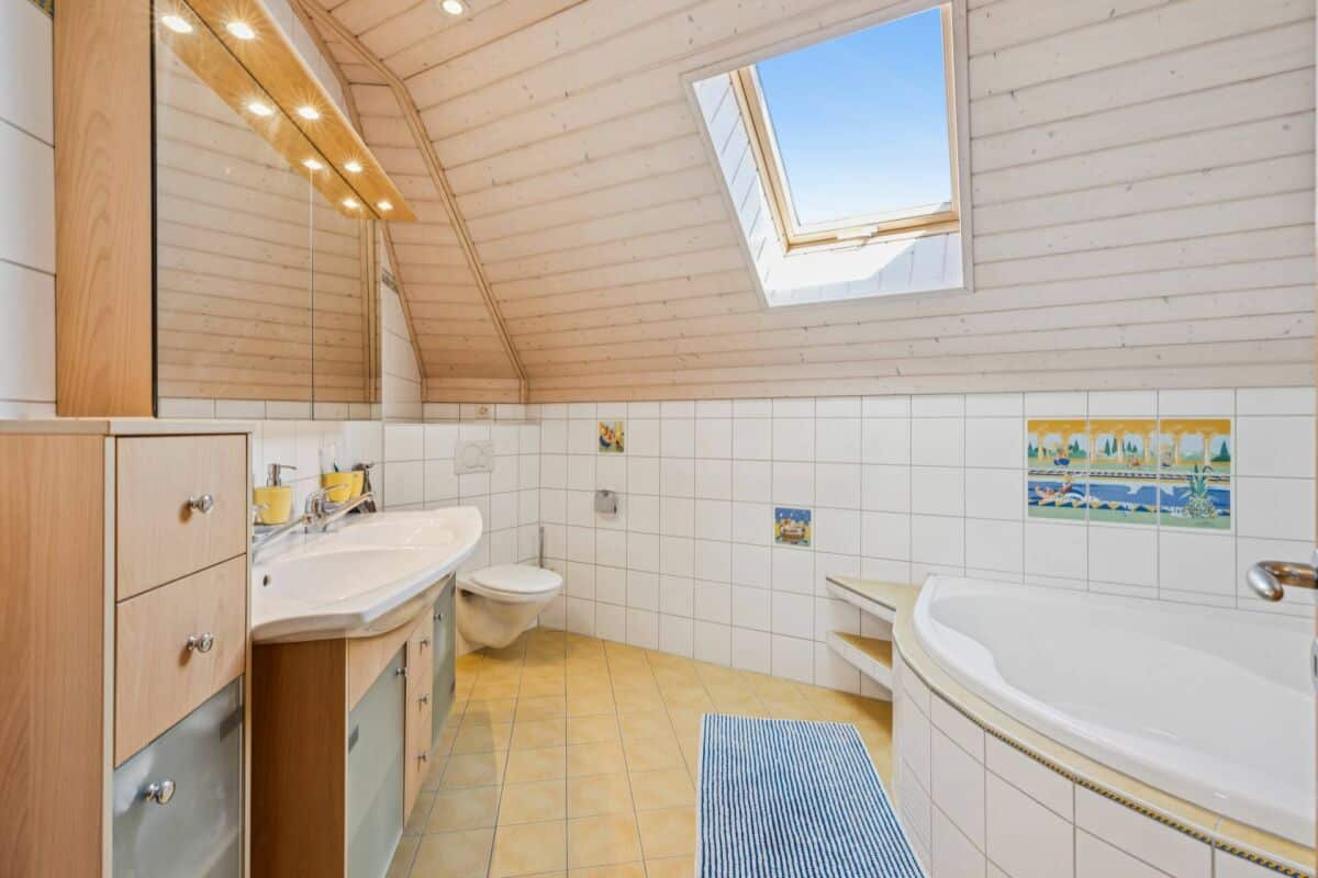 Dachgeschossbad mit Badewanne und Dachfenster