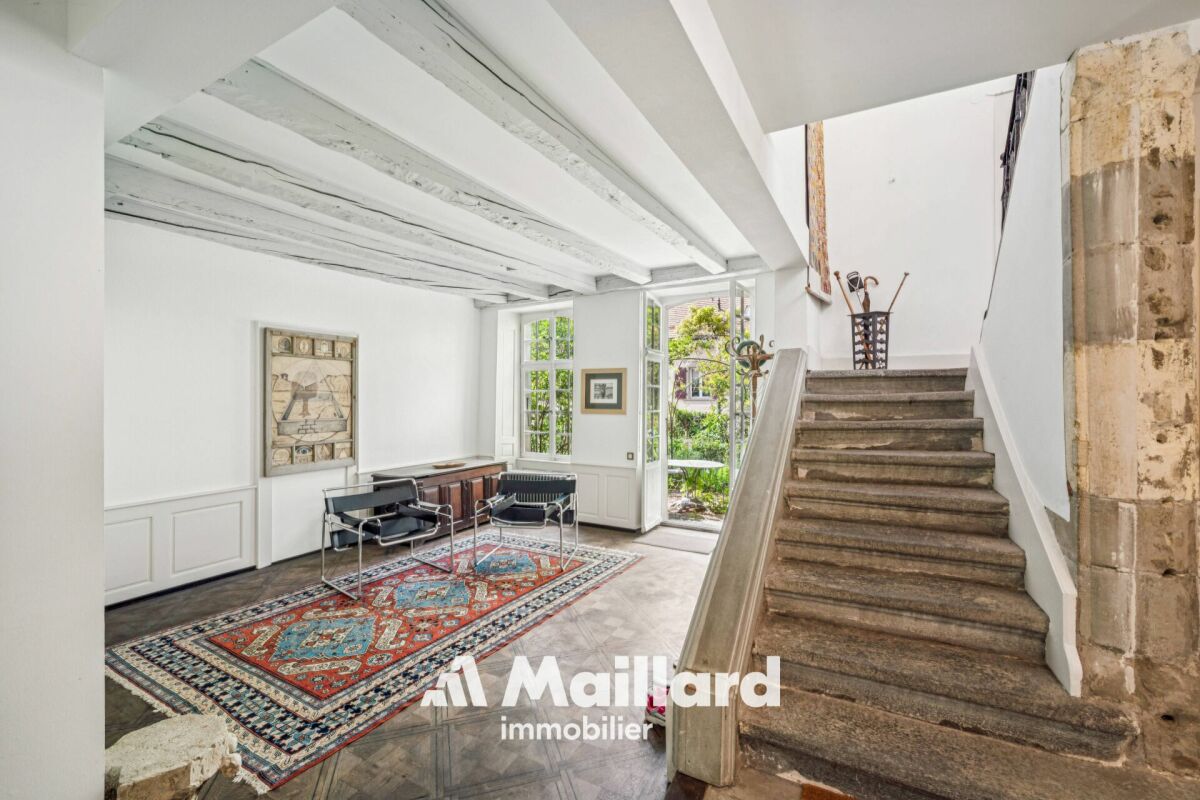 Heller Eingangsbereich mit Treppe und historischen Elementen