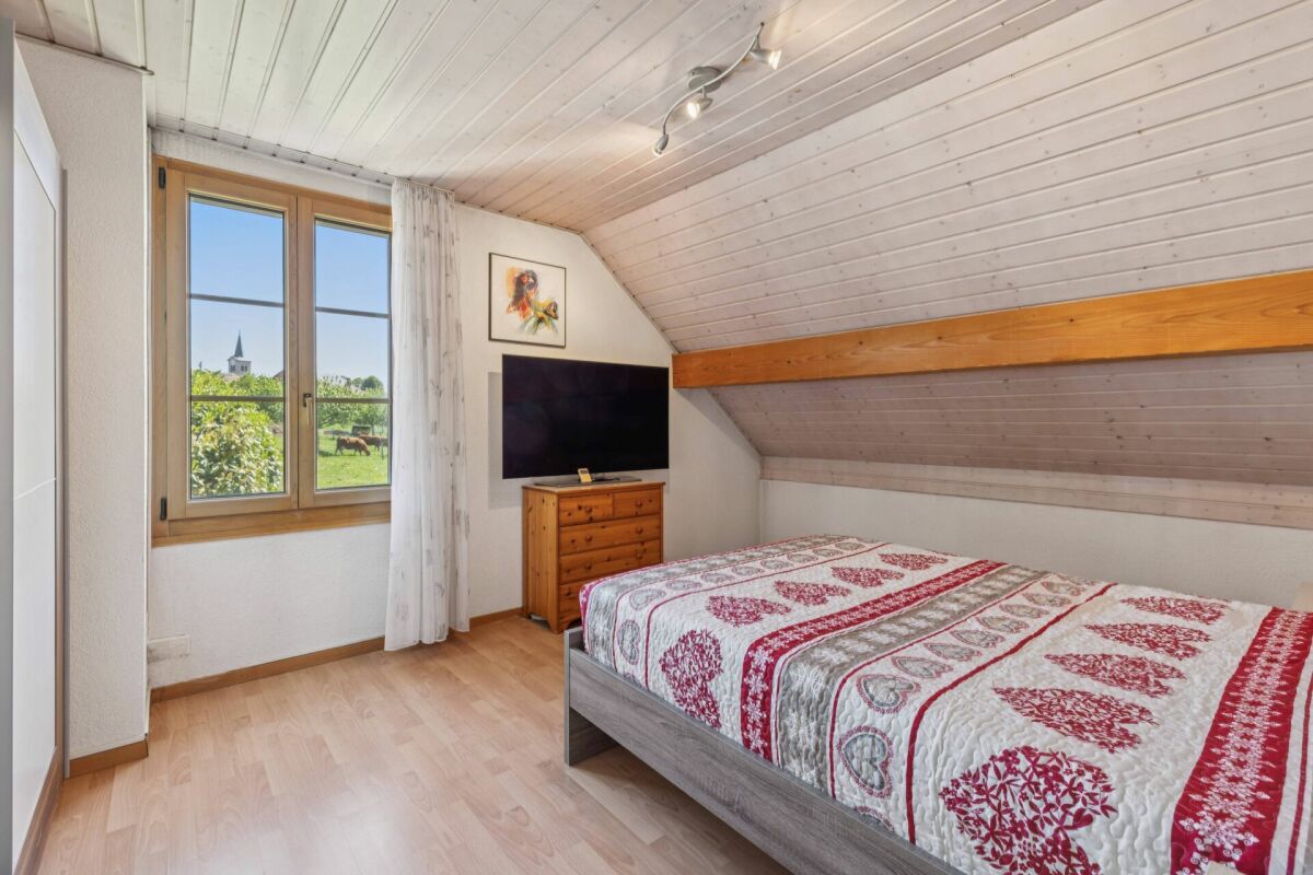 Gemütliches Dachgeschoss-Schlafzimmer mit Ausblick ins Grüne
