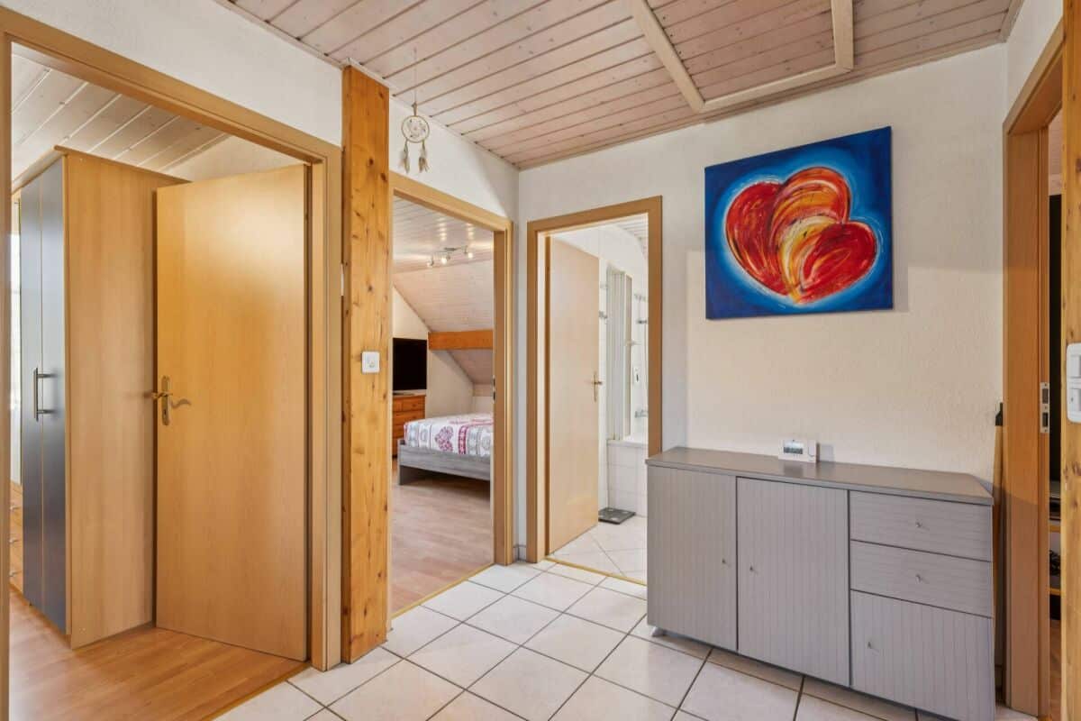 Heller Flur mit Holztüren und Schlafzimmerblick