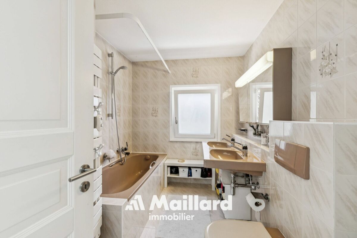 Kleines Badezimmer mit Badewanne und Doppelwaschbecken