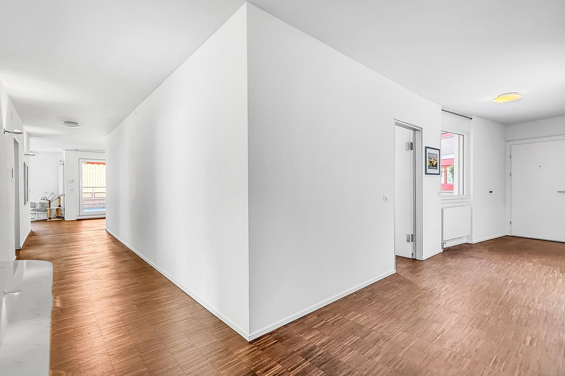 Heller, leerer Wohnungsflur mit Holzoptikboden
