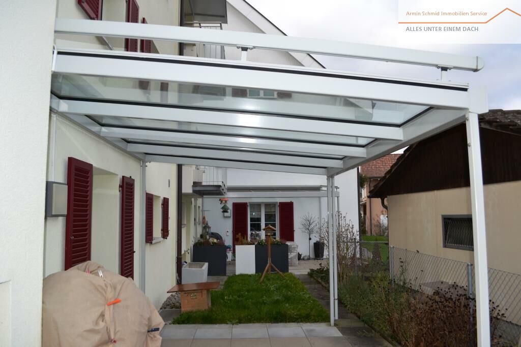 Überdachte Terrasse mit Markise und Hauszugang