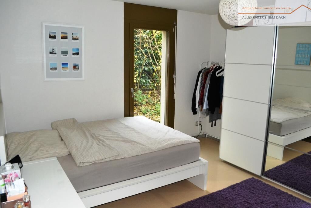 Helles Schlafzimmer mit offener Tür ins Grüne