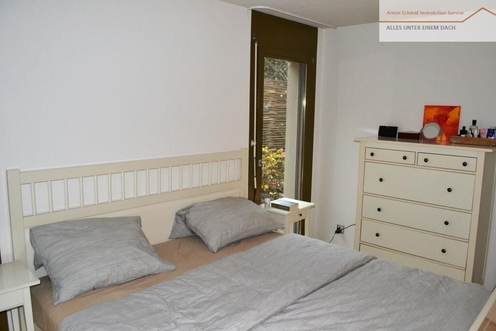 Helles Schlafzimmer mit schmalem Bett und Kommode