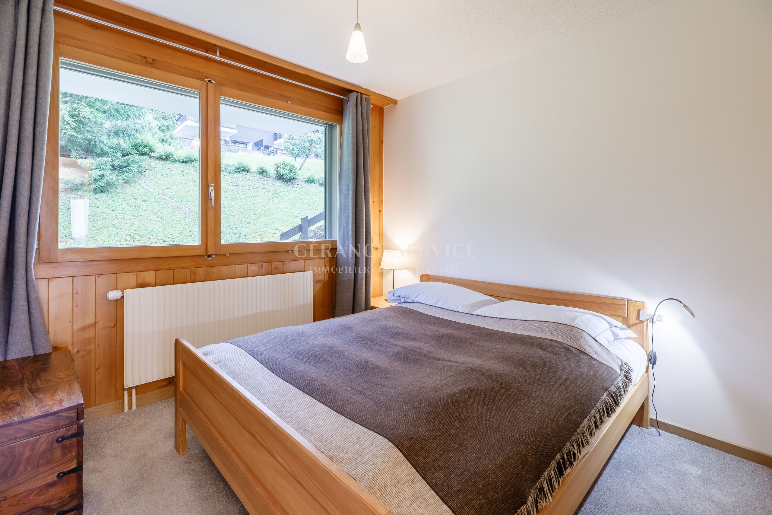 Helles Schlafzimmer mit großem Holzfenster
