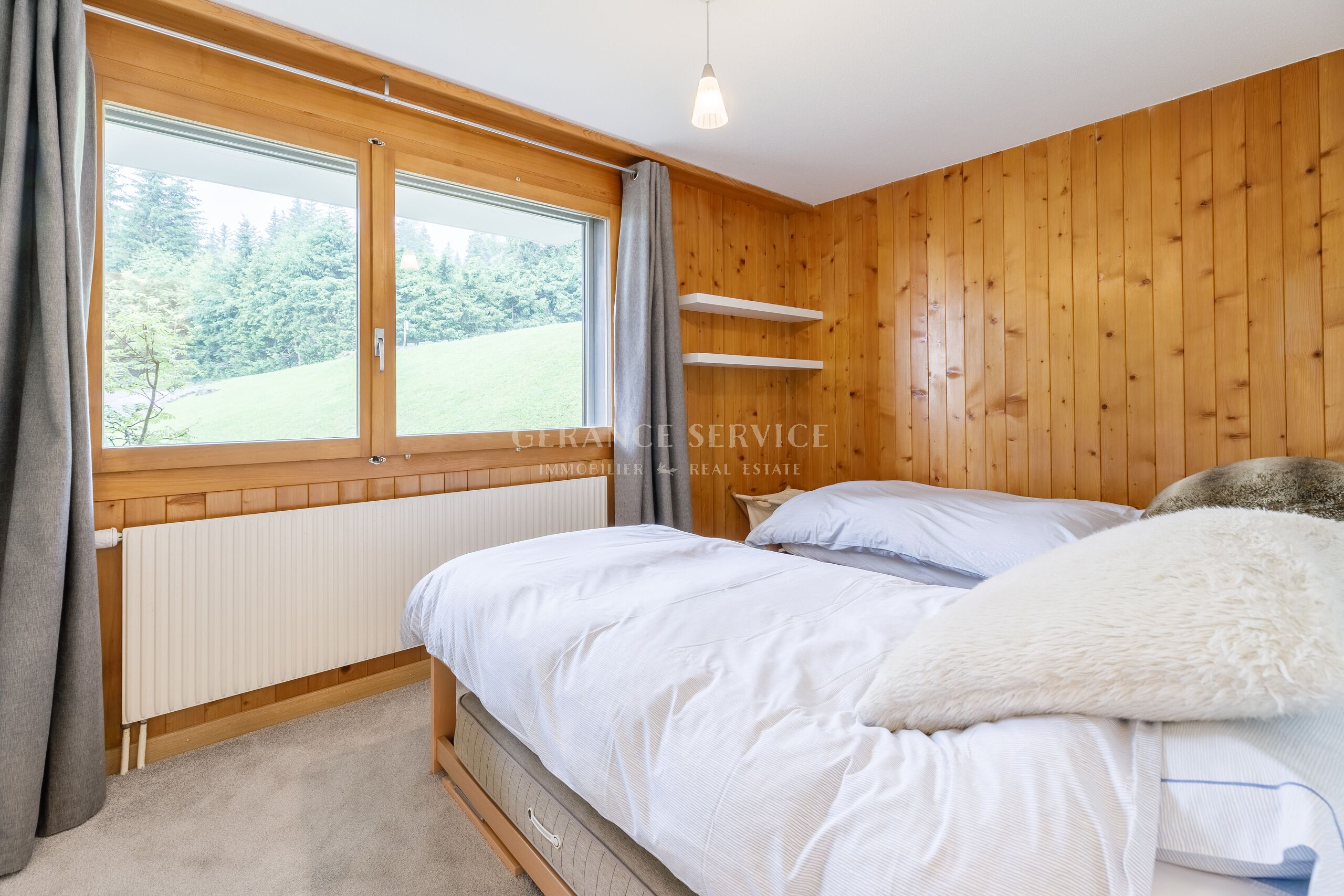 Helles Schlafzimmer mit Holzverkleidung und großem Fenster