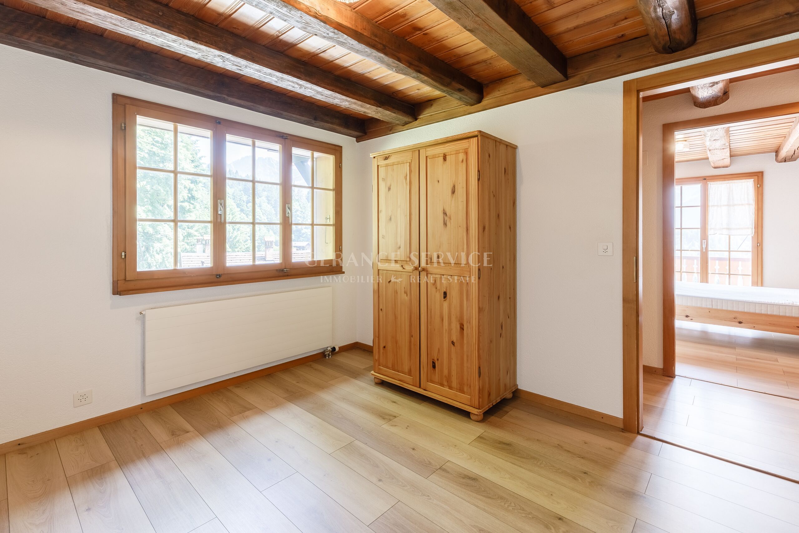 Heller Raum im Chalet-Stil mit Holzdecke und Blick ins Grüne