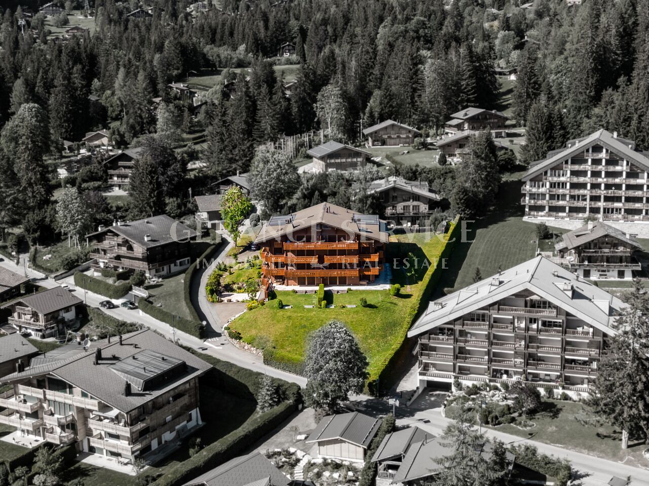 Alpine Ferienanlage mit Holzchalet im Vordergrund