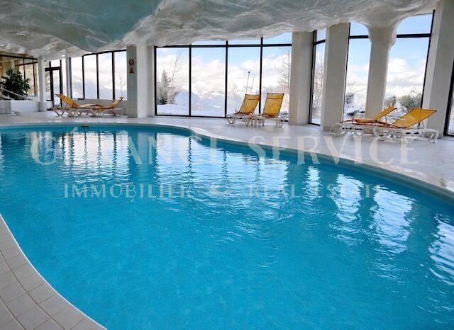 Innenpool mit Liegen und Panoramafenstern