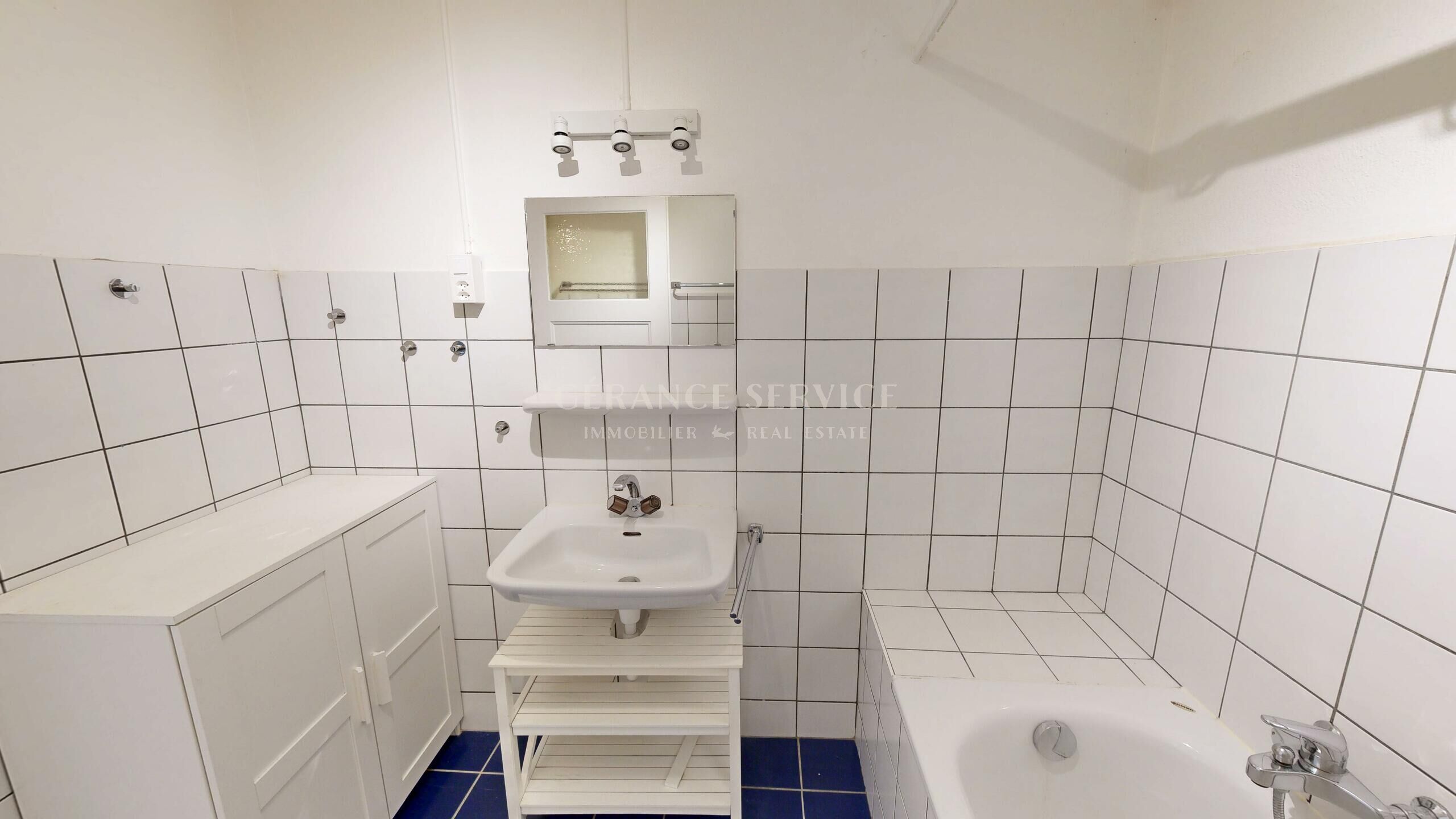 Kleines weiß gefliestes Badezimmer