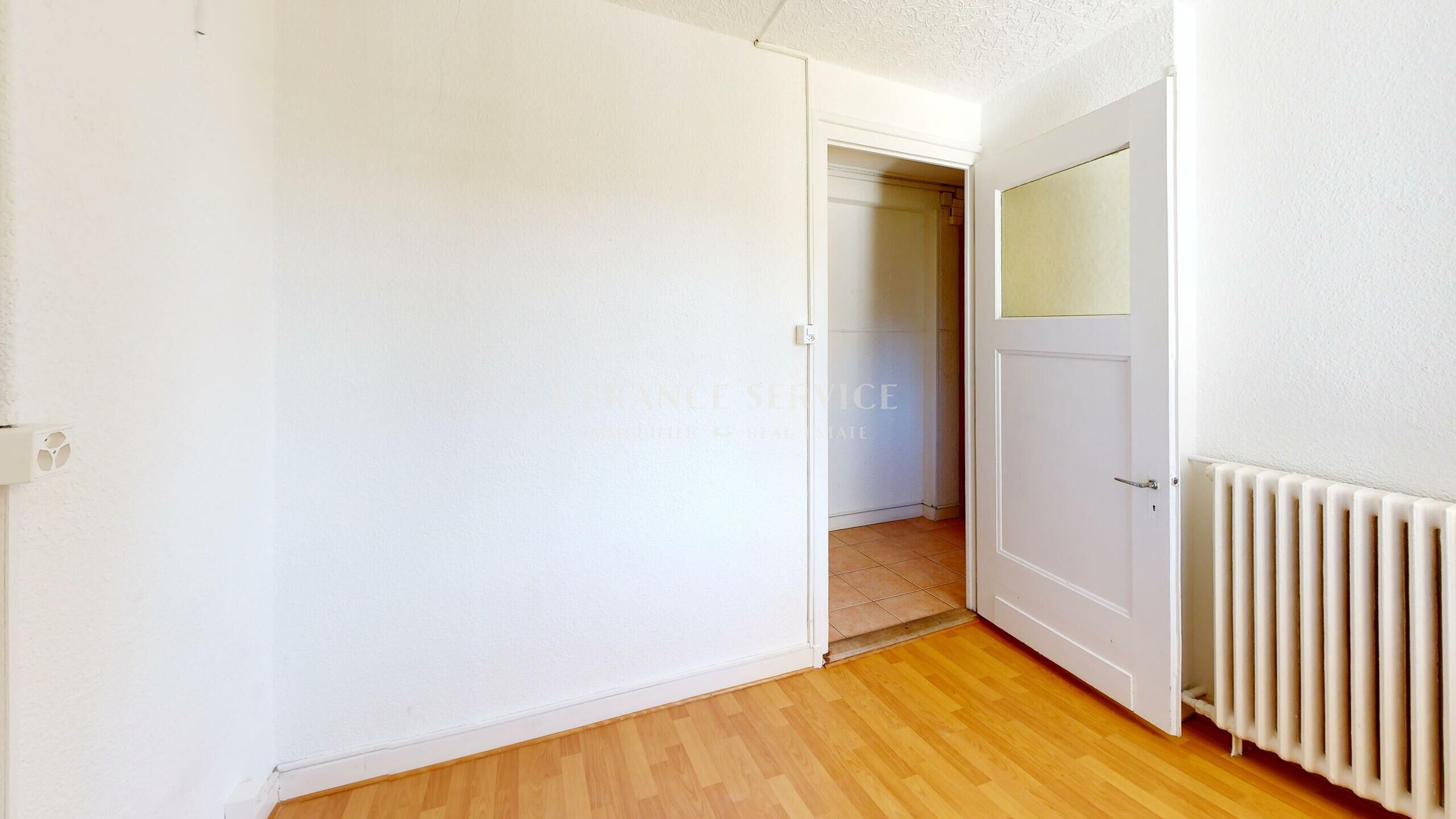 Leerer Raum mit offener Tür und Heizkörper