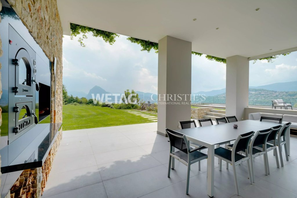 Überdachte Terrasse mit Grill und Bergblick