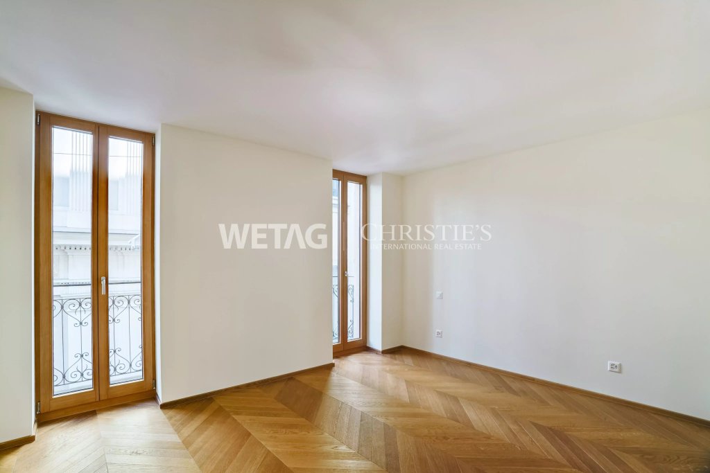 Heller leerer Wohnraum mit Holzboden und französischen Fenstern