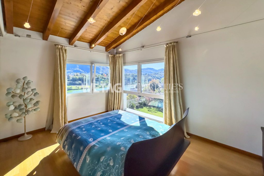 Helles Schlafzimmer mit großem Fenster und Bergblick