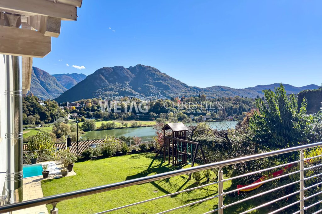 Blick von einem Balkon auf See, Garten und Berge