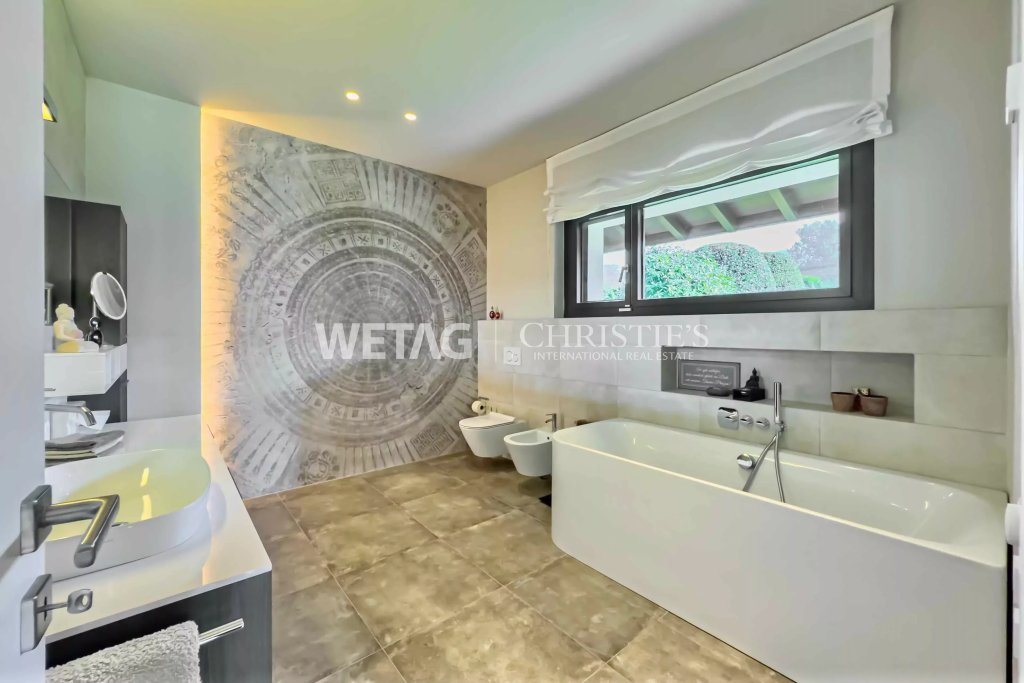 Modernes Badezimmer mit freistehender Badewanne und Wandkunst