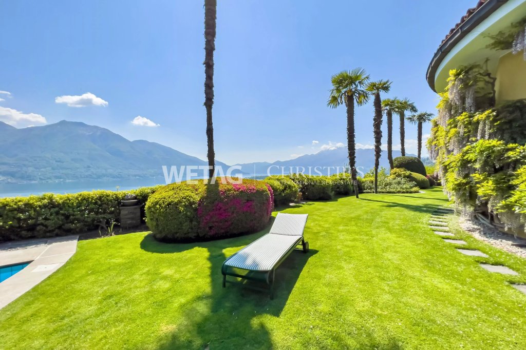 Exklusive Gartenanlage am See mit Liege und Palmen