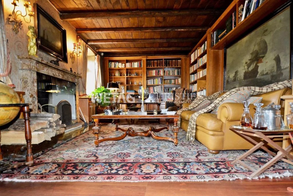 Gemütliches, rustikales Wohnzimmer mit Kamin und Bücherregalen