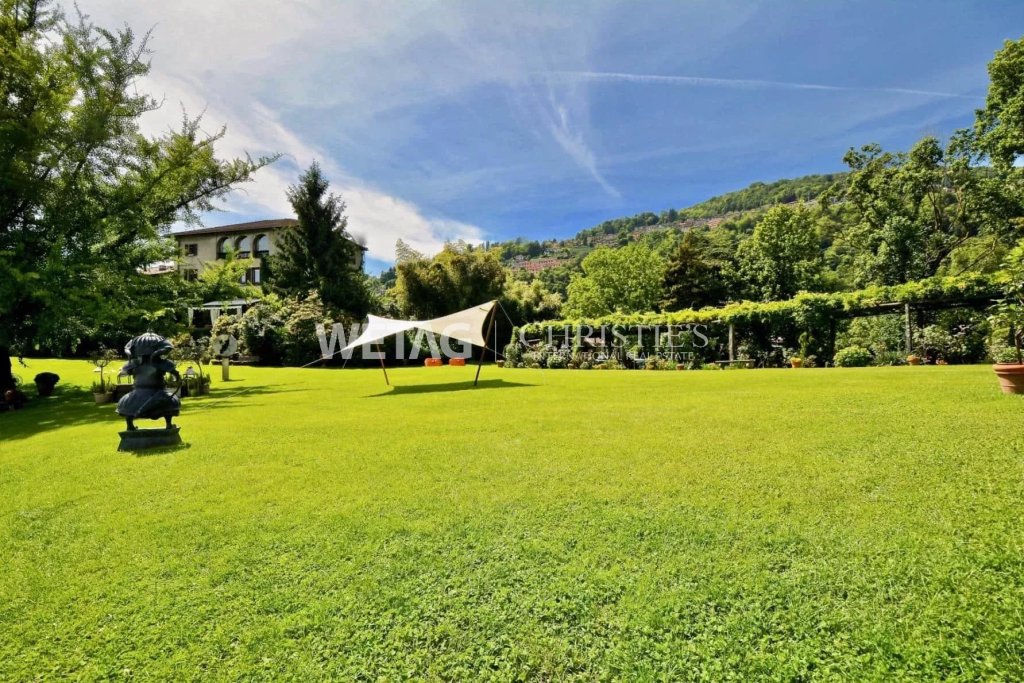 Großer Garten mit Rasen und Blick auf bewaldete Hügel