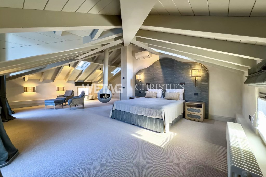 Dachgeschoss-Schlafzimmer mit sichtbaren Dachbalken