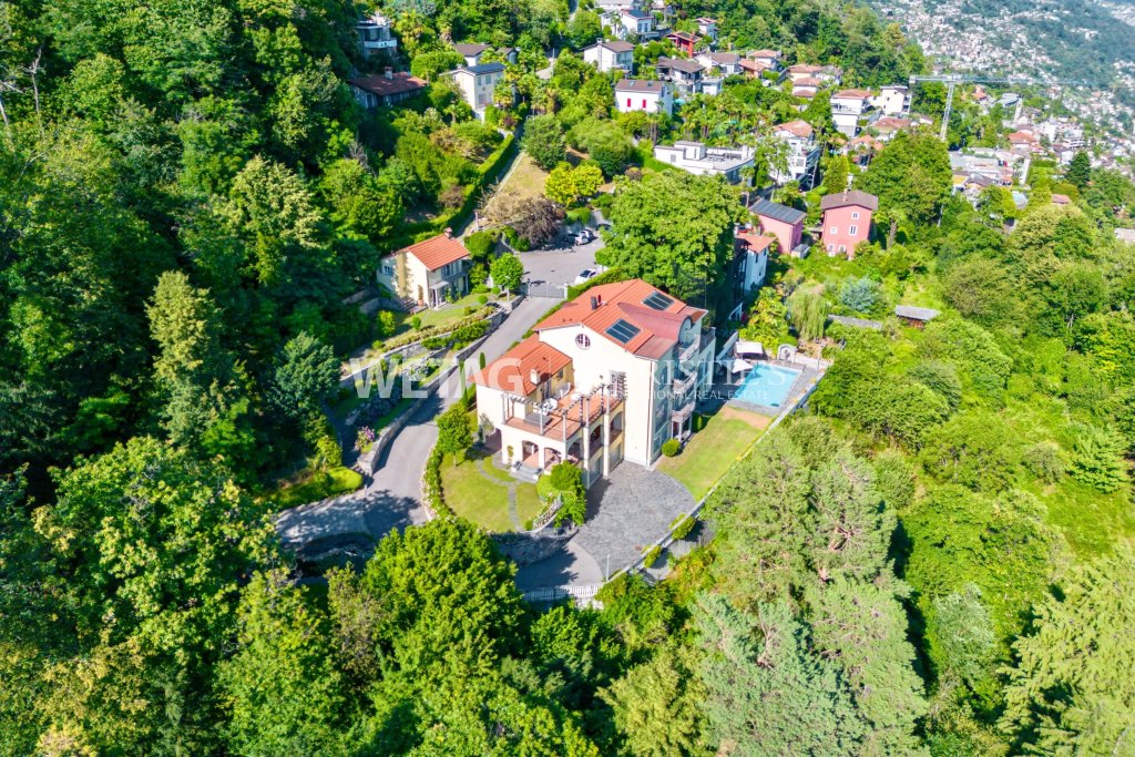 Luftaufnahme einer Villa mit Pool in grüner Hanglage