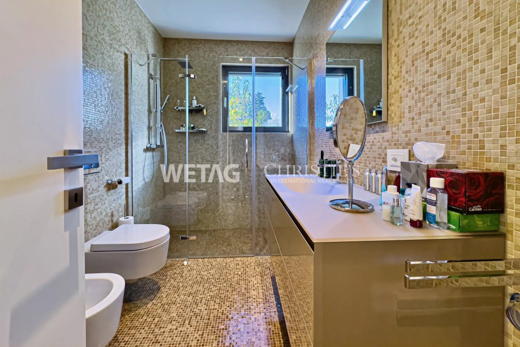 Modernes Badezimmer mit Mosaikfliesen und Glasdusche