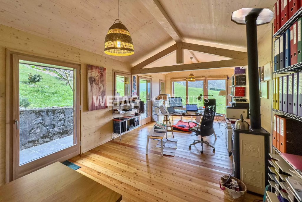 Holzverkleidetes Arbeitszimmer mit Kaminofen
