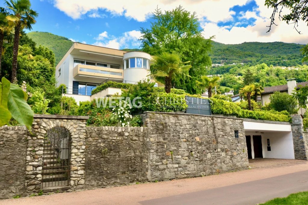 Luxuriöse Villa in Hanglage mit Steinmauer und Garten