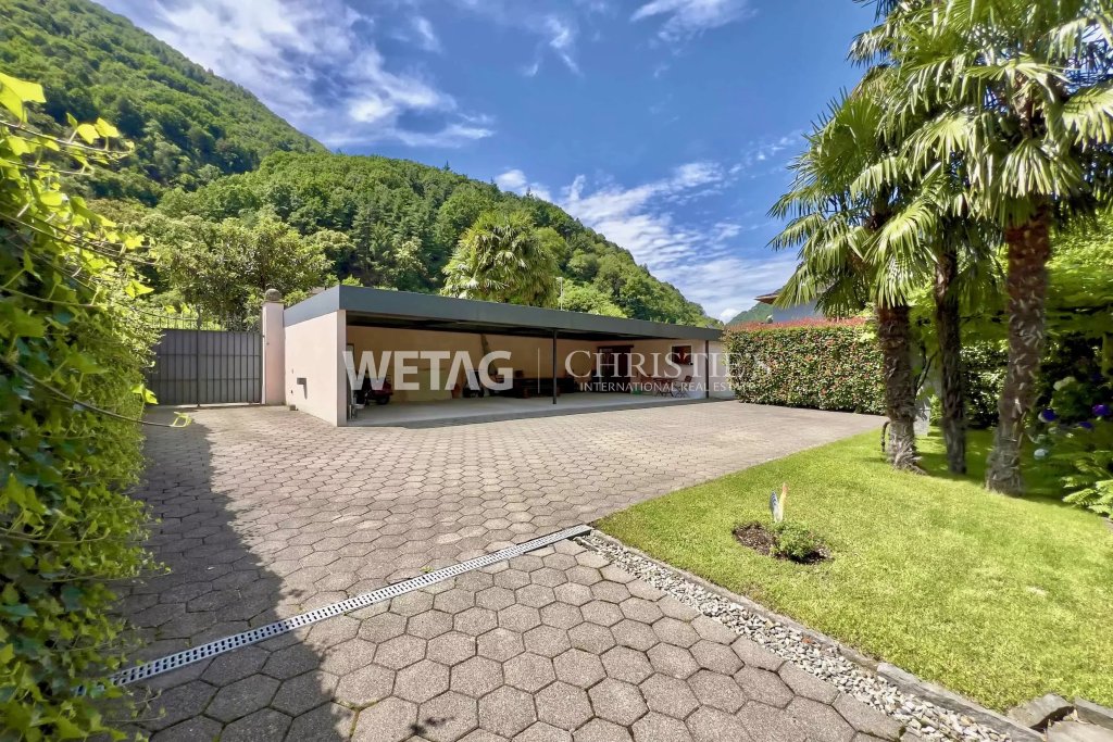 Außenbereich mit Carport und tropischer Bepflanzung