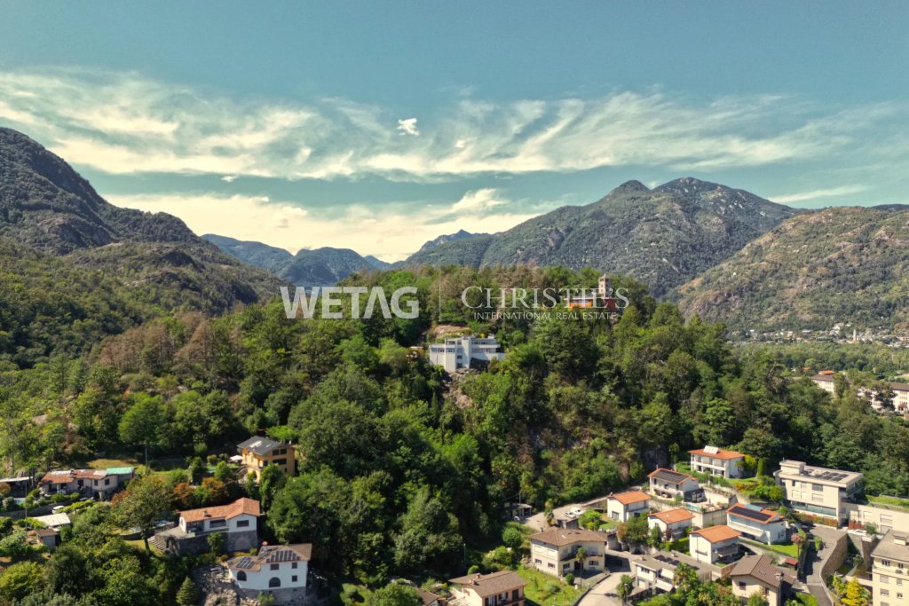 Luftaufnahme einer grünen Berglandschaft mit Siedlung