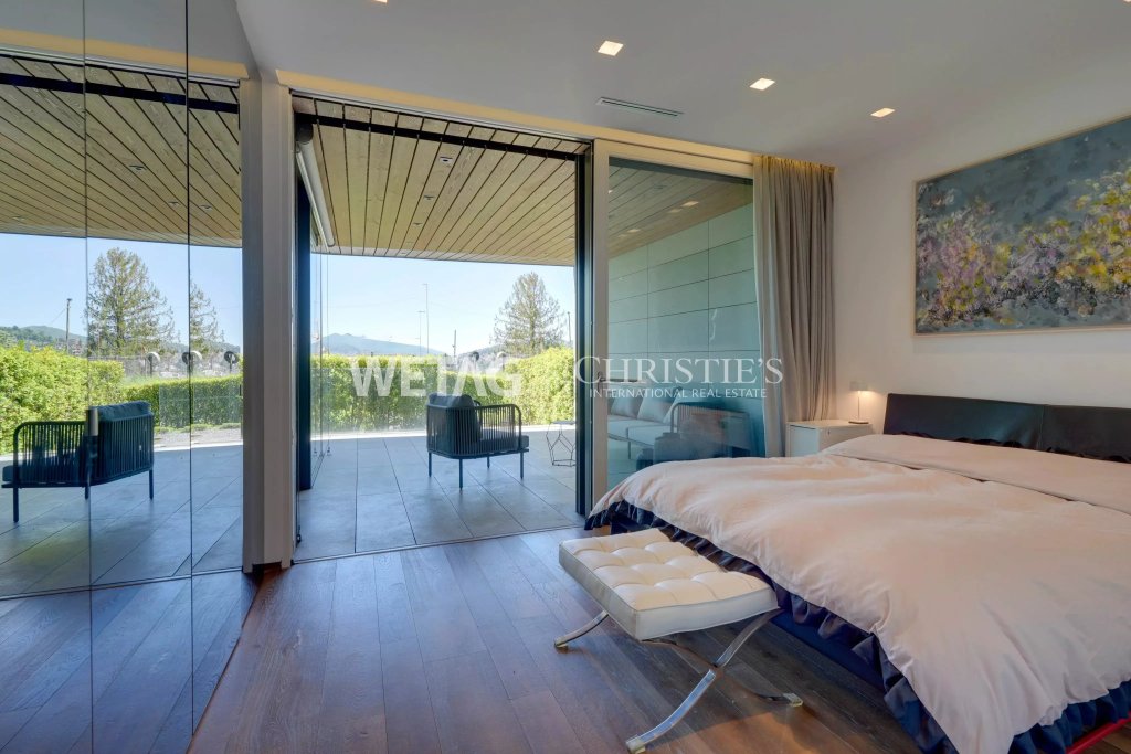 Modernes Schlafzimmer mit großer Glasfront und Terrasse