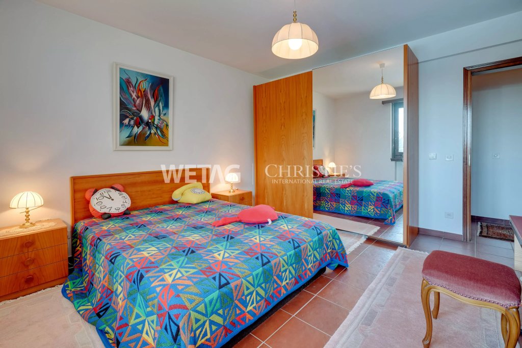 Schlafzimmer mit farbigem Bett und Holzdetails
