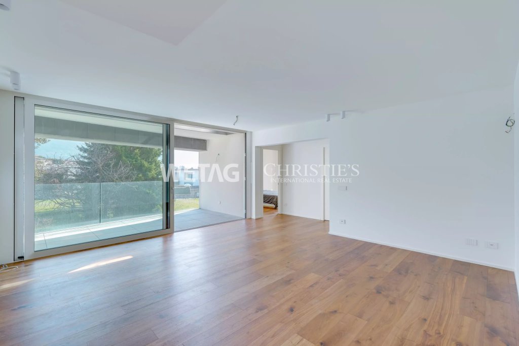 Heller, leerer Wohnraum mit großem Schiebefenster