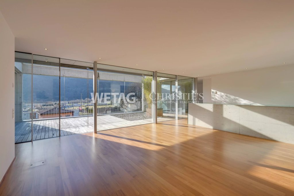 Offener Wohnraum mit Panoramafenstern und Terrasse