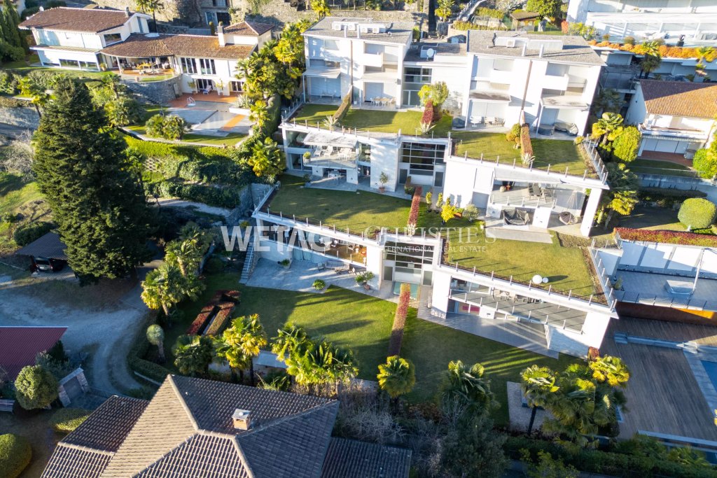 Luftaufnahme einer modernen Villenanlage mit terrassierten Gebäuden und großen Dachgärten