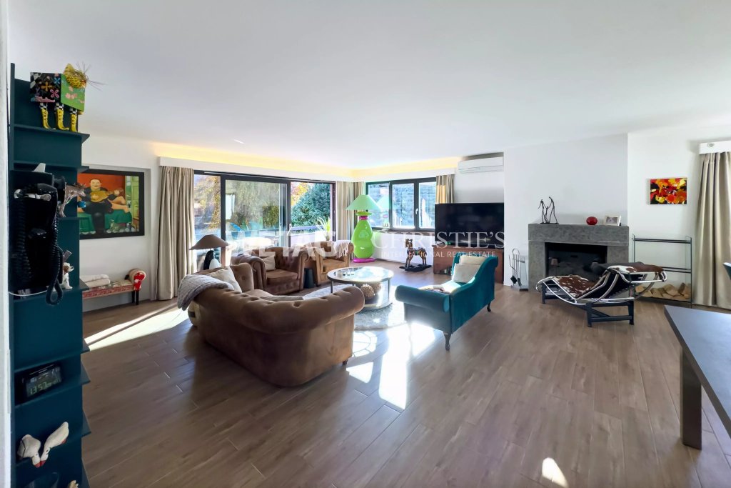 Großzügiges Wohnzimmer mit Kamin und Gartenblick