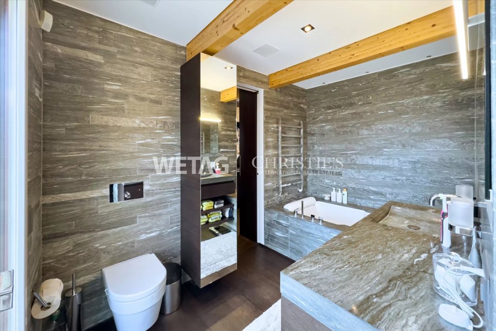 Luxuriöses Badezimmer mit Naturstein und Holzdeckenbalken