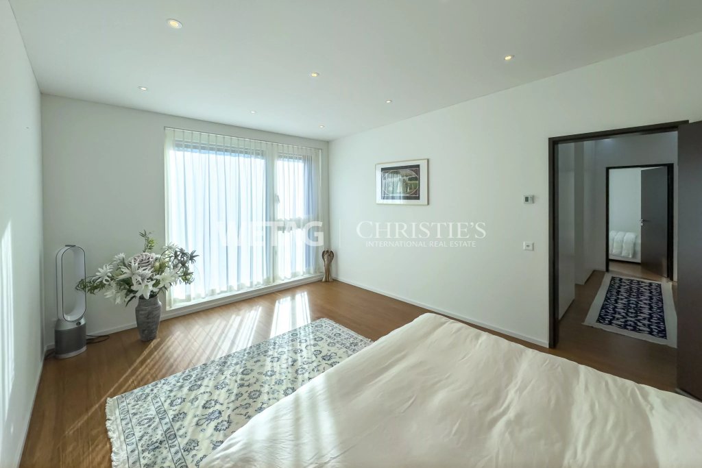 Helles Schlafzimmer mit Holzboden und großen Fenstern