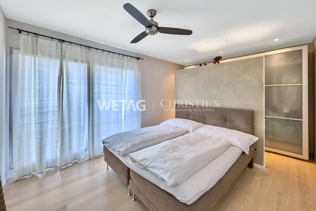 Schlafzimmer mit großem Fenster und Doppelbett